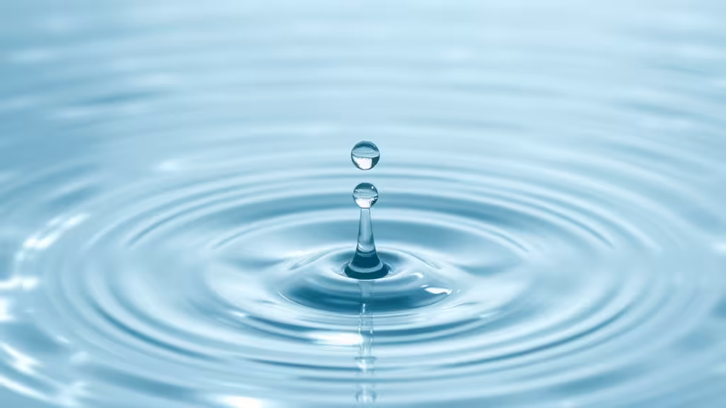 Molécule d'eau captée dans une goutte tombant dans une surface d'eau limpide.