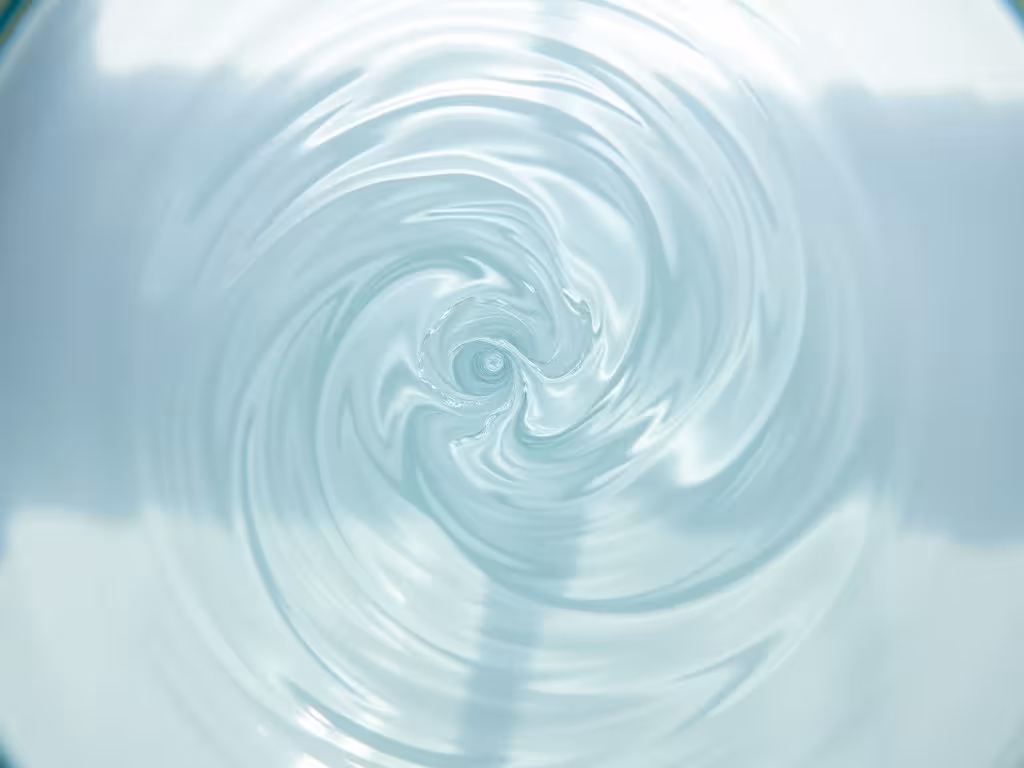 Eau formant un motif tourbillonnant dans un récipient, montrant le mouvement naturel de l'eau